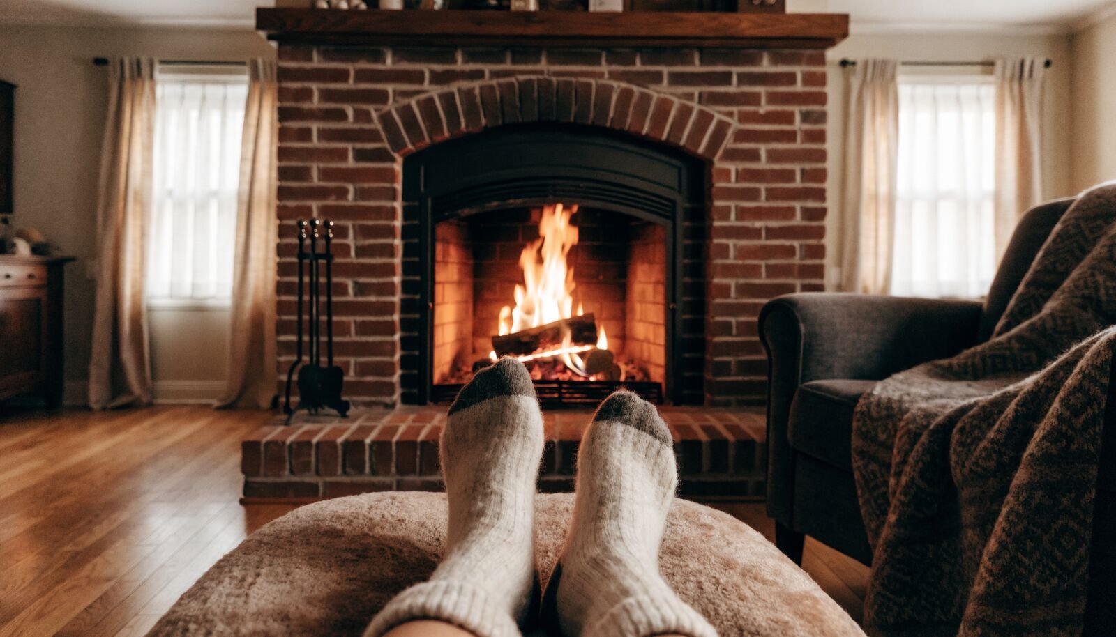 Feet up in wool socks by a traditional wood fire